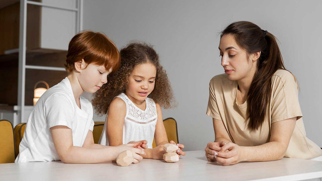 Two children and an adult at a table playing with wooden geometric sensory shapes