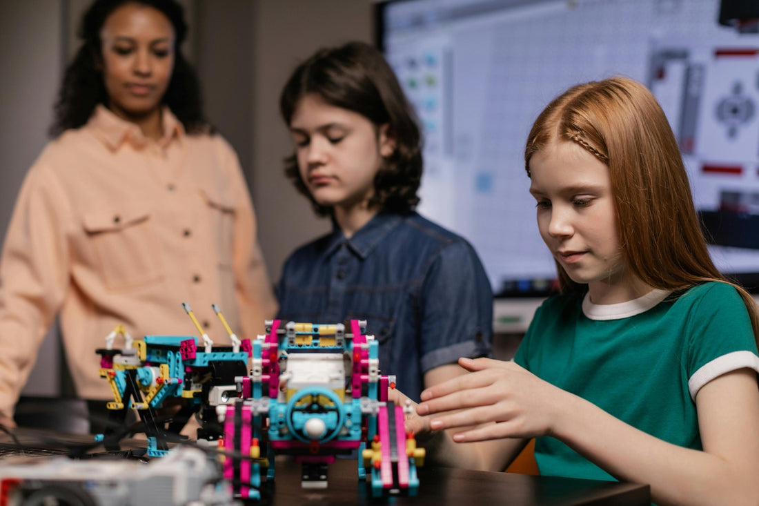 Teacher and two students building a robotics project in a STEAM class